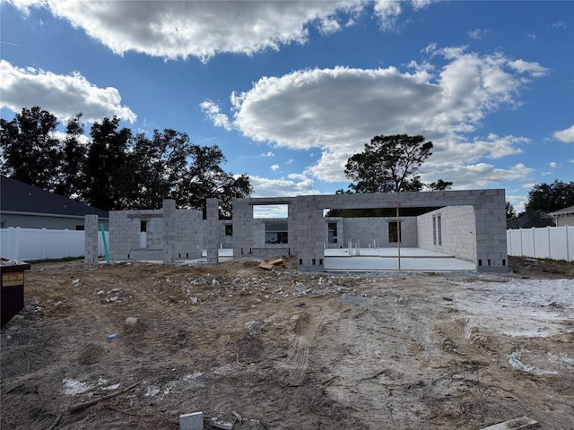 rear view of property with a patio, concrete block siding, and fence