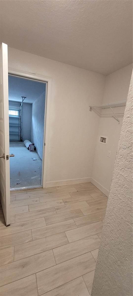 washroom featuring washer hookup, light wood-style flooring, and baseboards