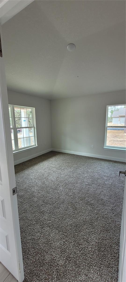 unfurnished room featuring plenty of natural light and baseboards