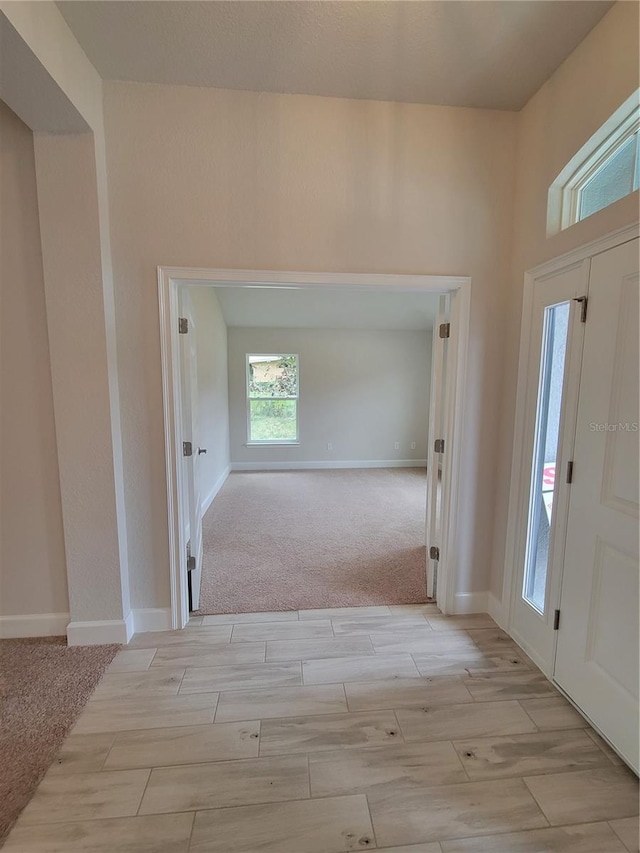 foyer entrance featuring baseboards and wood finish floors