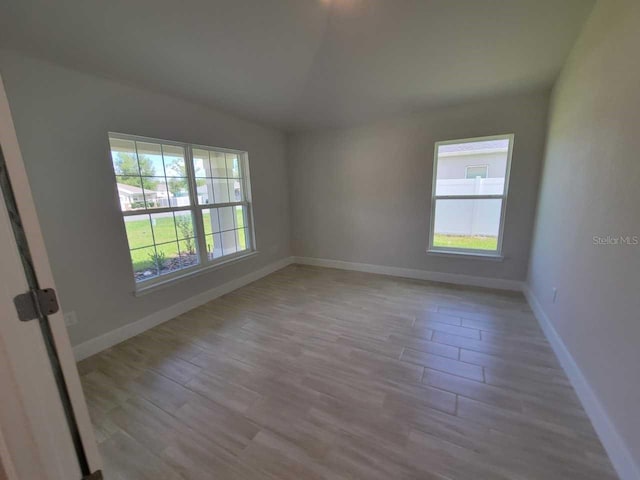 11610 SW 59th Ter, Ocala, FL 34476 - empty room with wood finished floors and vaulted ceiling