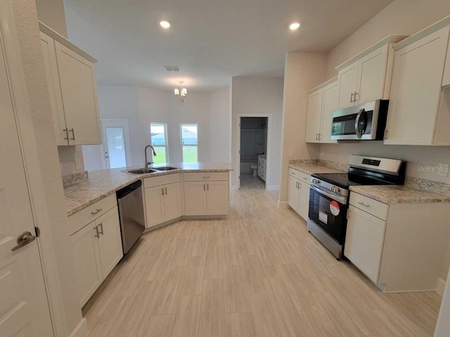 11610 SW 59th Ter, Ocala, FL 34476 - kitchen with stainless steel appliances, a peninsula, recessed lighting, white cabinets, and light wood-type flooring