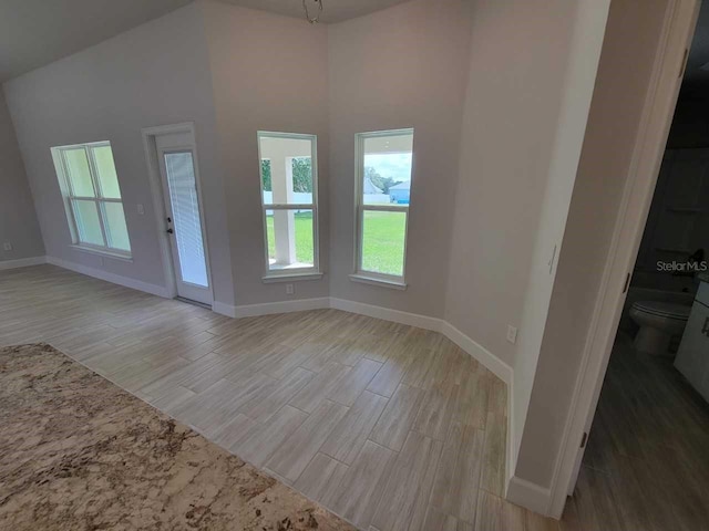11610 SW 59th Ter, Ocala, FL 34476 - unfurnished living room featuring plenty of natural light, light wood finished floors, and a high ceiling