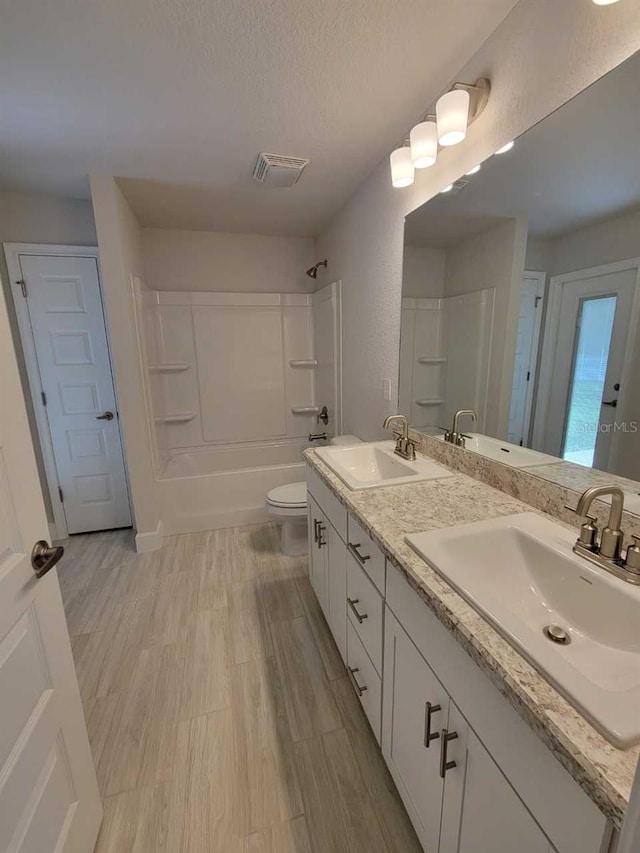11610 SW 59th Ter, Ocala, FL 34476 - full bath with double vanity, shower / tub combination, a textured ceiling, and wood finished floors