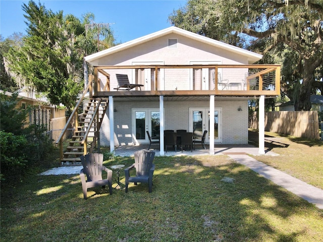 rear view of house with french doors, a patio, and a yard