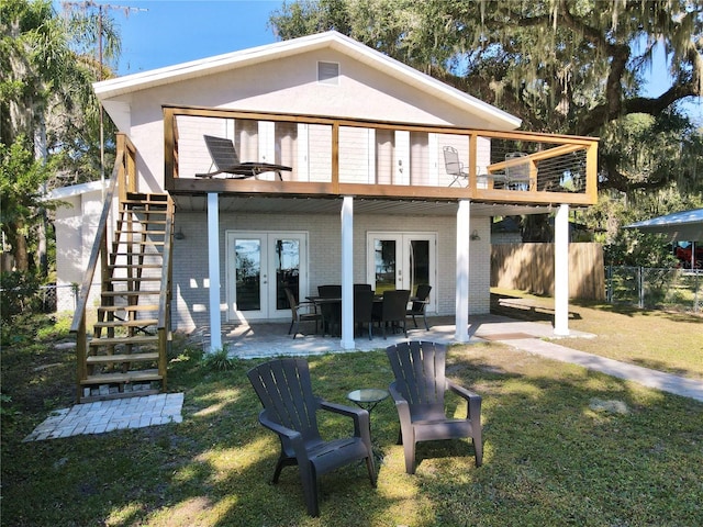 back of property with french doors, a yard, a deck, and a patio area