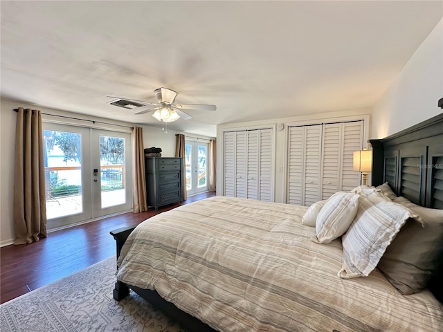 bedroom with access to exterior, ceiling fan, french doors, dark hardwood / wood-style flooring, and two closets