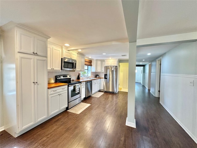 kitchen with stainless steel appliances, dark wood-type flooring, sink, white cabinets, and butcher block countertops