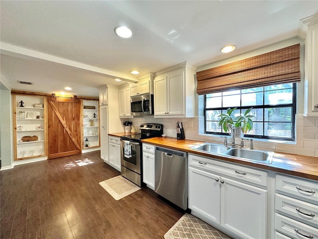 kitchen featuring appliances with stainless steel finishes, a barn door, and white cabinetry