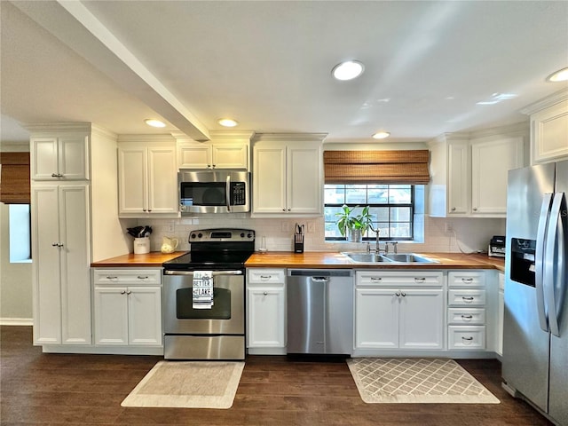 kitchen featuring white cabinets, butcher block counters, and stainless steel appliances