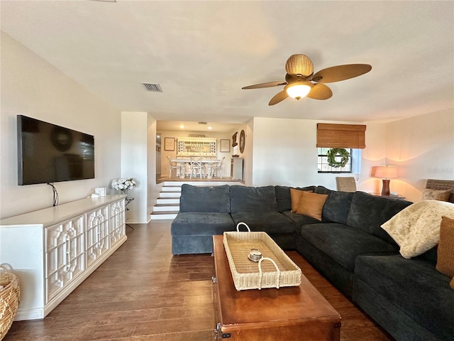 living room featuring ceiling fan and dark hardwood / wood-style flooring