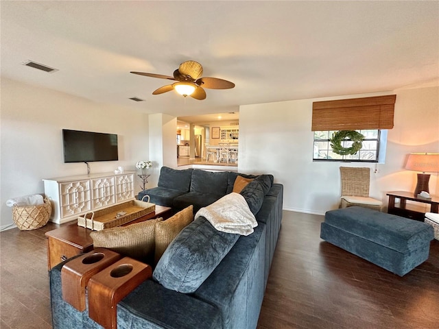 living room featuring ceiling fan and dark wood-type flooring