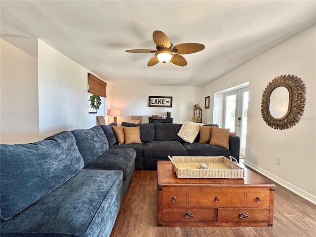 living room with ceiling fan and dark wood-type flooring