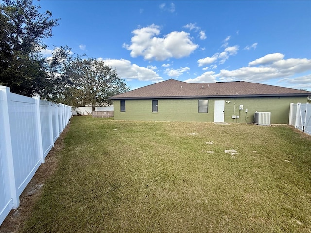 back of house with a lawn and central air condition unit