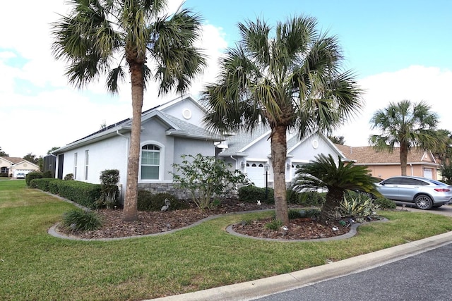 view of front of property featuring a front lawn and a garage