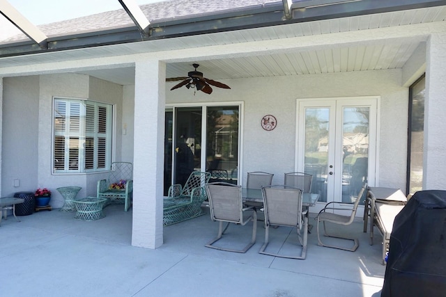 view of patio featuring area for grilling, glass enclosure, and ceiling fan