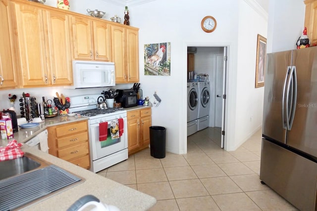 kitchen featuring white appliances, washer and clothes dryer, crown molding, and light tile patterned flooring