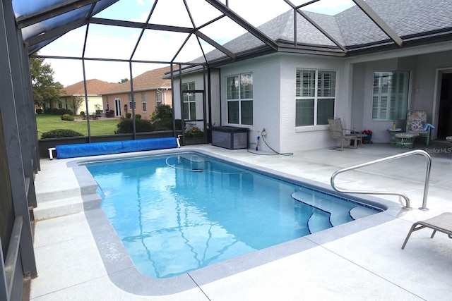 view of swimming pool with a patio area and a lanai