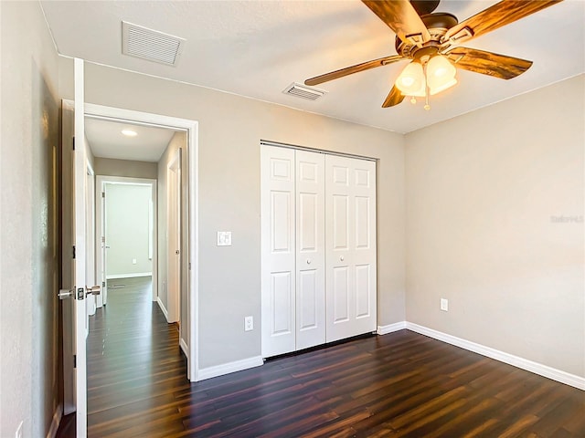 unfurnished bedroom featuring dark hardwood / wood-style flooring, a closet, and ceiling fan