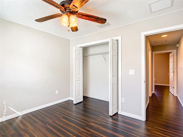 unfurnished bedroom featuring a textured ceiling, dark hardwood / wood-style flooring, a closet, and ceiling fan