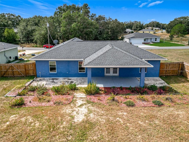 back of property with a lawn and a patio area