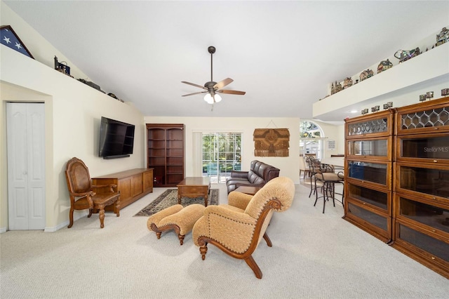 carpeted living room with ceiling fan and lofted ceiling