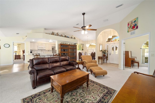 carpeted living room featuring high vaulted ceiling and ceiling fan