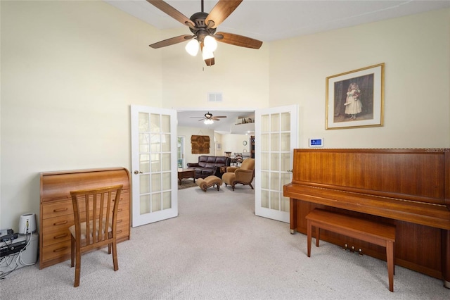 living area with ceiling fan, light carpet, and french doors