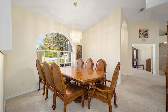 carpeted dining space featuring vaulted ceiling and a notable chandelier