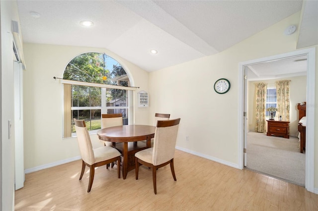 dining area featuring light hardwood / wood-style floors and lofted ceiling