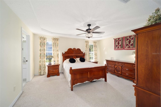 carpeted bedroom with connected bathroom, ceiling fan, and a textured ceiling