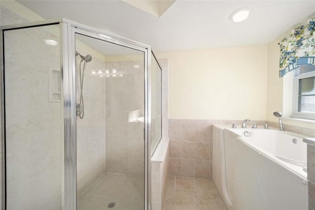 bathroom with plus walk in shower, tile patterned flooring, and tile walls