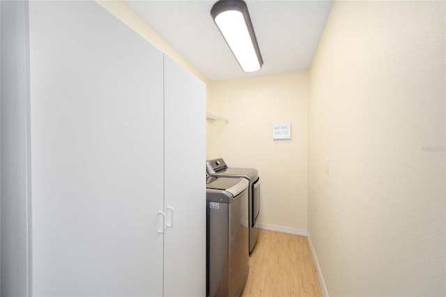 clothes washing area with light hardwood / wood-style floors and independent washer and dryer