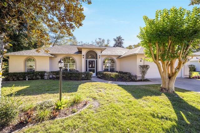 5336 SW 109th Place Rd, Ocala, FL 34476 - view of front of house featuring stucco siding, an attached garage, a front yard, and concrete driveway