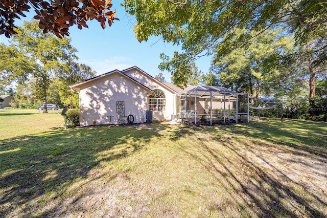 rear view of property with a lanai and a yard