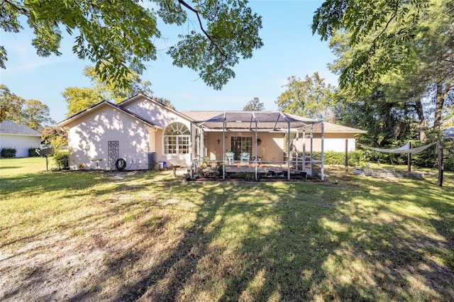 rear view of property featuring a lawn and a lanai