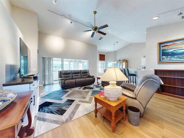 living room with ceiling fan, rail lighting, light hardwood / wood-style floors, and high vaulted ceiling