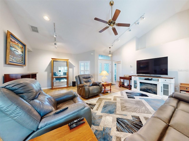 living room with ceiling fan, high vaulted ceiling, light hardwood / wood-style floors, and track lighting