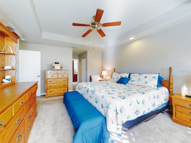 carpeted bedroom featuring a tray ceiling, ceiling fan, and a closet