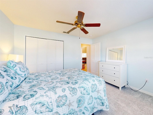 bedroom with a closet, ceiling fan, and light colored carpet