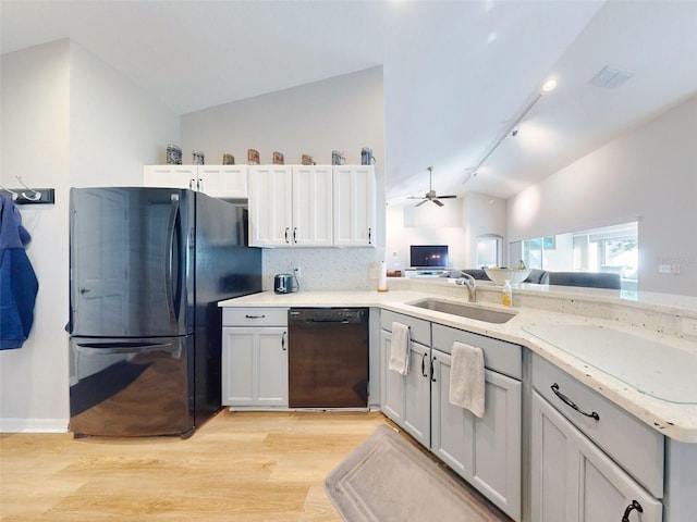 kitchen featuring lofted ceiling, black appliances, sink, ceiling fan, and light wood-type flooring