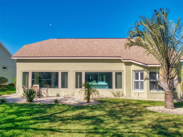 rear view of property featuring a lawn and a patio area