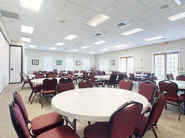 carpeted dining room with a drop ceiling