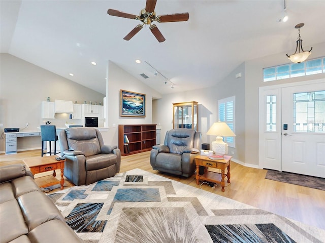 living room with ceiling fan, track lighting, light hardwood / wood-style floors, and lofted ceiling