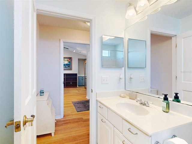 bathroom featuring hardwood / wood-style floors, vanity, and vaulted ceiling