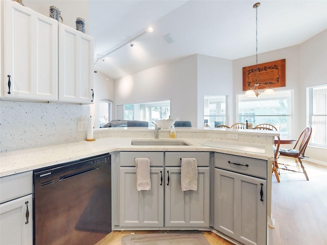 kitchen with light stone counters, sink, kitchen peninsula, and black dishwasher