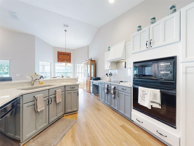 kitchen with black appliances, gray cabinetry, white cabinetry, and pendant lighting