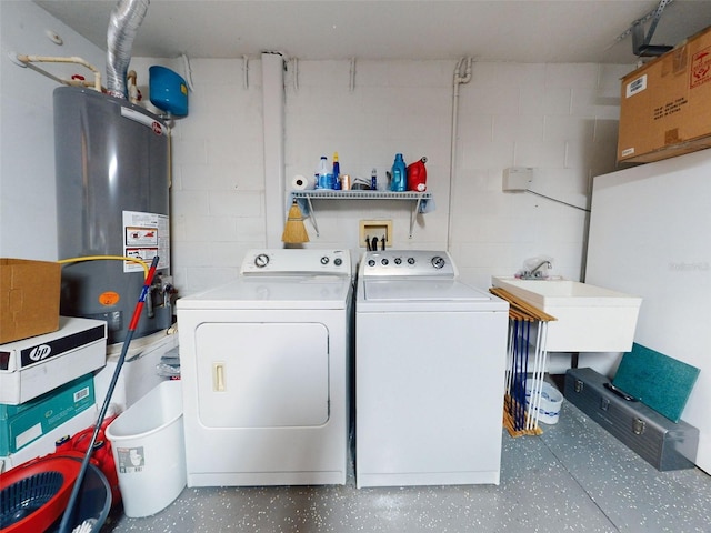 clothes washing area with washing machine and clothes dryer, sink, and water heater