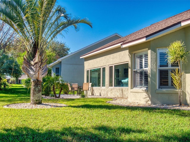 view of side of home with a yard