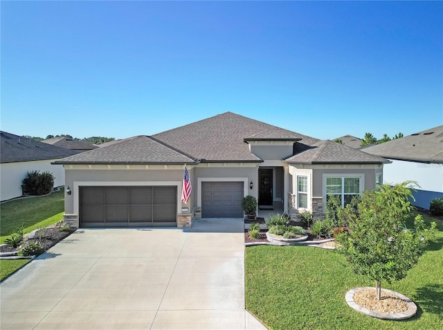 prairie-style home featuring a garage and a front lawn